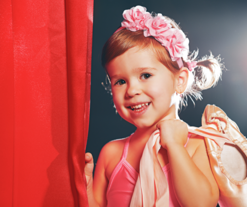 Young ballerina in costume at a dance recital as an example of a photo you could use in a recital program ad